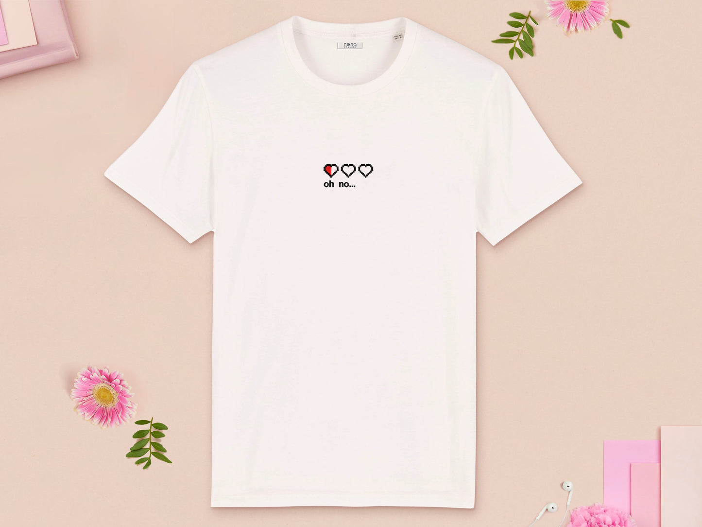 A white short sleeved t-shirt with an embroidered red and black design of almost empty gaming health hearts and the text oh no...