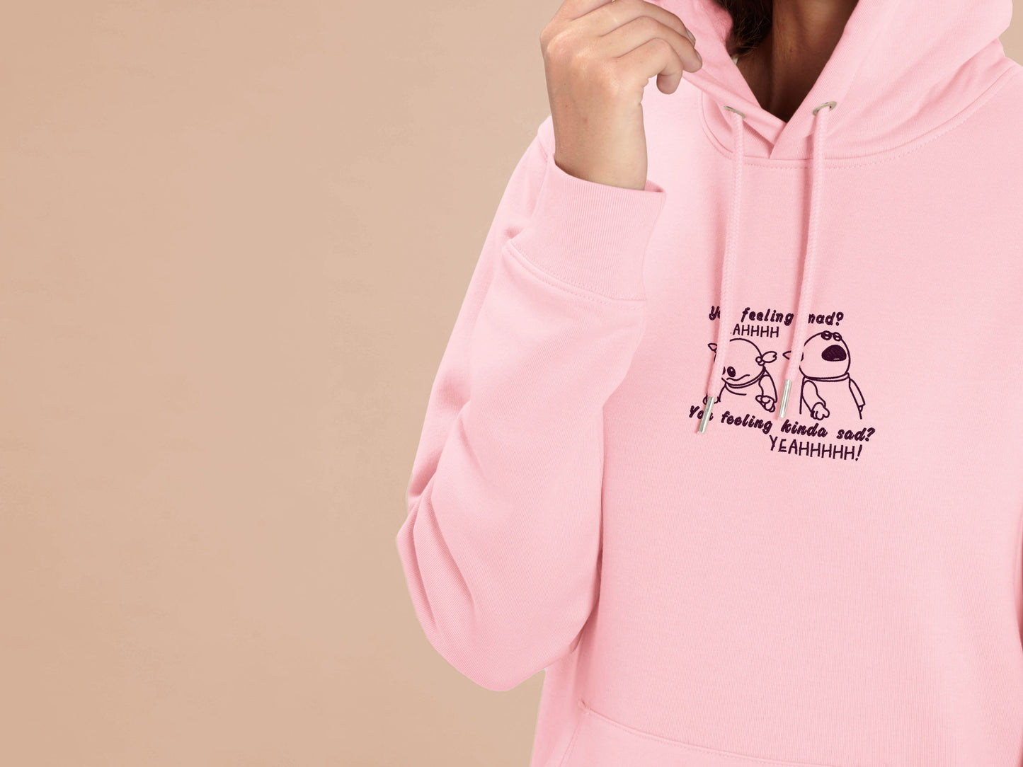 Woman wearing an embroidered pink fleece hoodie  design of the character Mona from the puppet show Nanalan in two angry poses from the viral tiktok meme with the text You feeling mad? Yeah. You Feeling Kinda Sad? YEAHHHH!