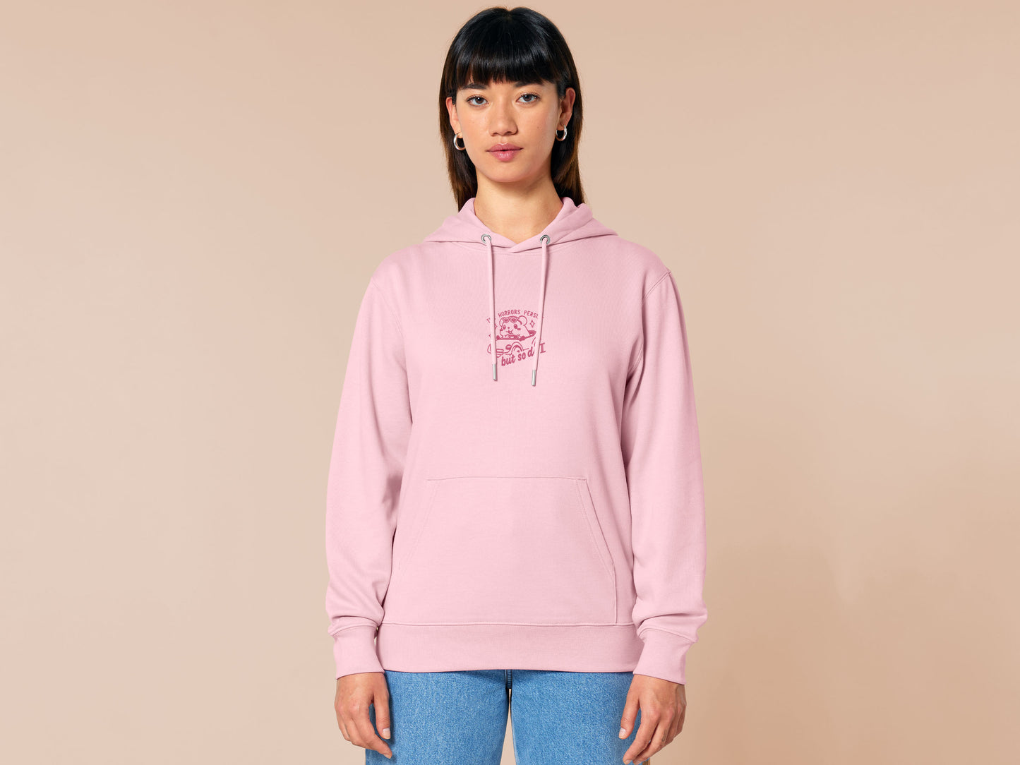 Pink embroidered hoodie with a cute chibi guinea pig hamster wearing heart-shaped sunglasses and driving a little pink car surrounded by the quote the horrors persist but so do I.