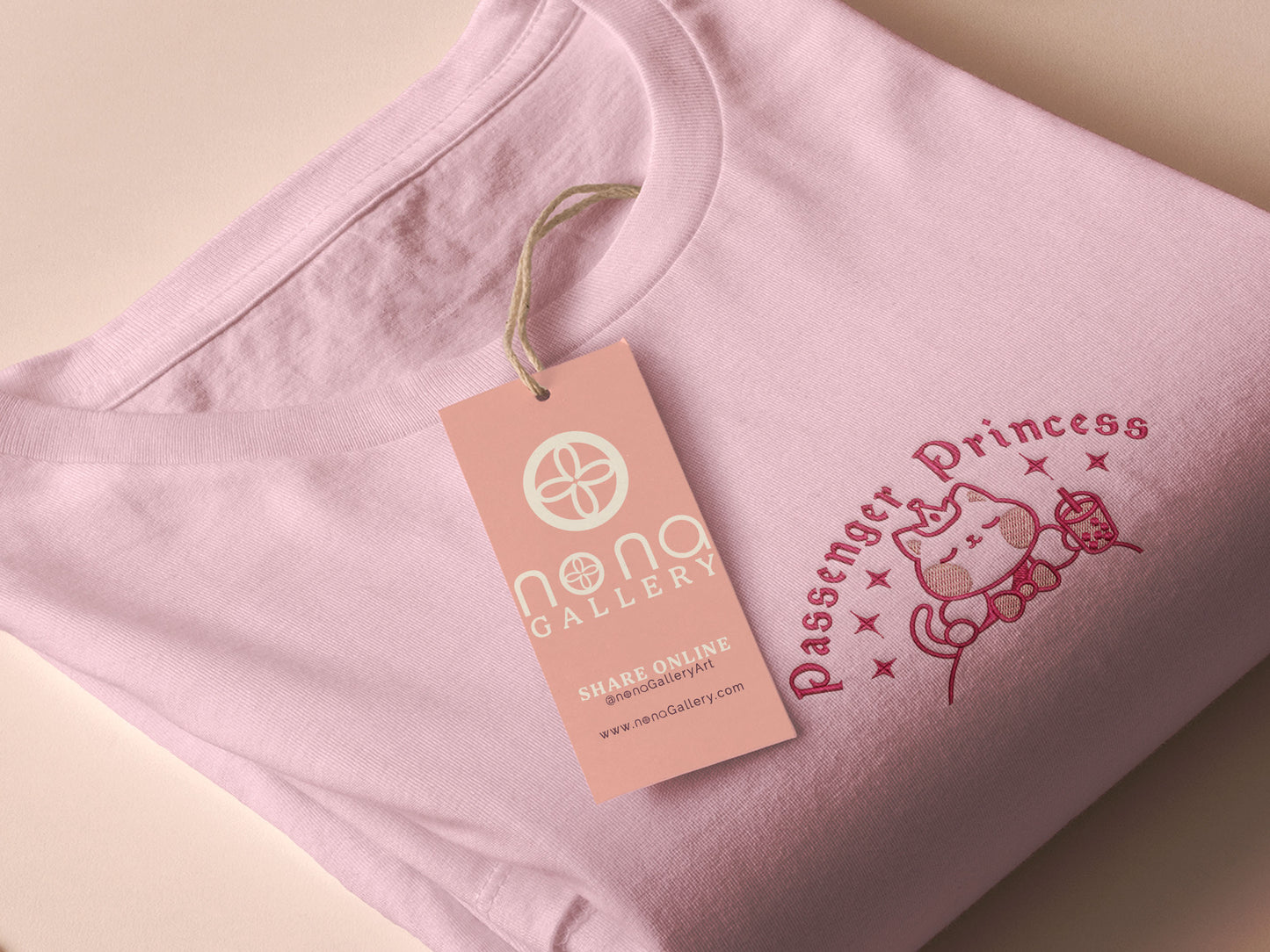 Pink embroidered t-shirt with a cute chibi princess cat wearing a crown and holding a boba tea surrounded by the quote passenger princess