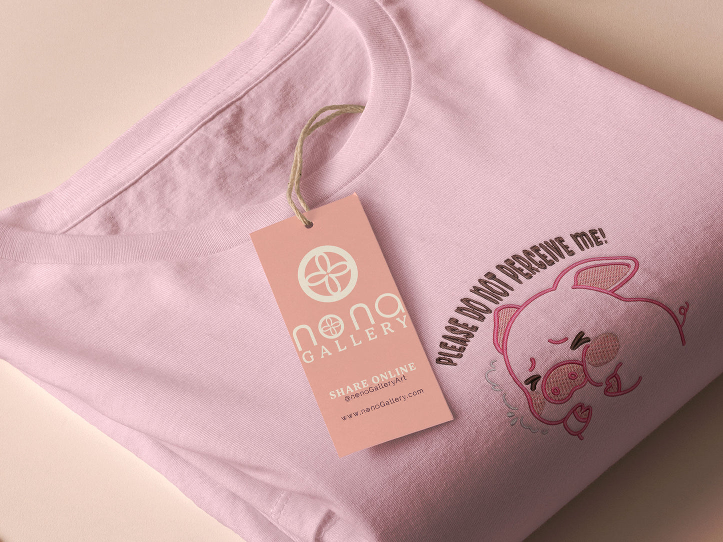Pink embroidered t-shirt with a cute chibi panicking pig surrounded by the quote please don't perceive me
