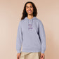 Purple embroidered hoodie with a cute design of a chibi owlbear crying holding a d20 dice that has rolled a one with the quote Crying Is A Free Action