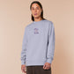 Purple embroidered sweater with a cute design of a chibi owlbear crying holding a d20 dice that has rolled a one with the quote Crying Is A Free Action