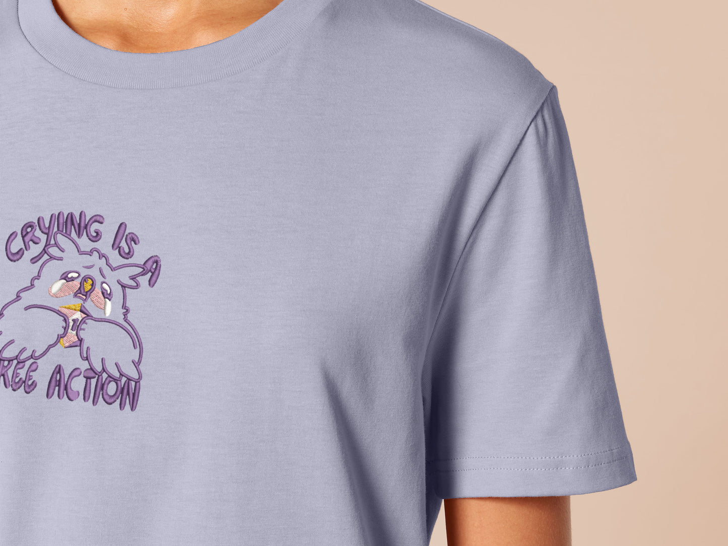 Purple embroidered tshirt with a cute design of a chibi owlbear crying holding a d20 dice that has rolled a one with the quote Crying Is A Free Action
