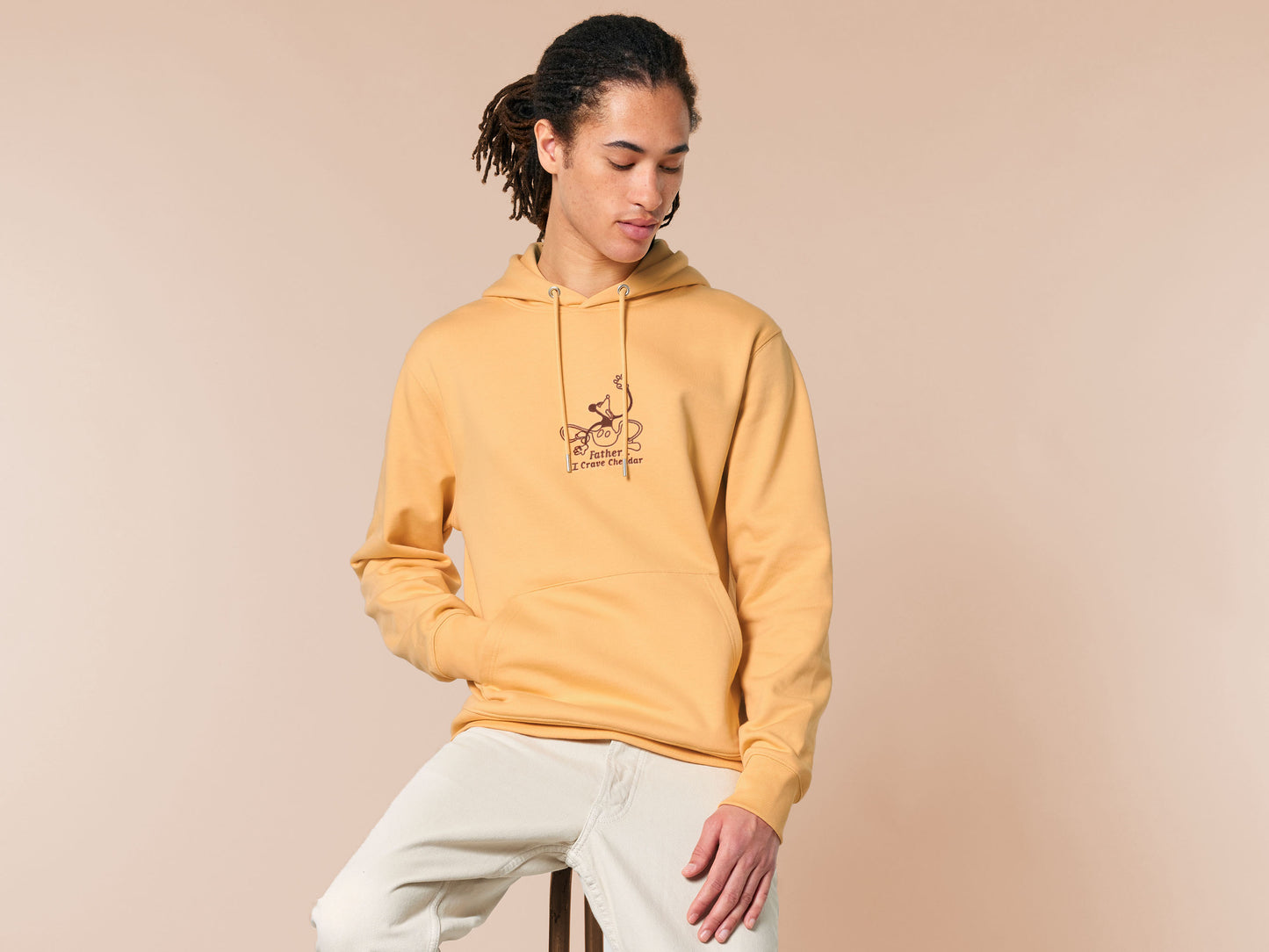 A yellow crew neck long sleeve hoodie, with an embroidered black thread design of a mickey mouse like creature grasping the air with the text Father... I crave cheddar