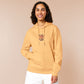A yellow hoodie with an embroidered design of a cute grumpy red dragon playing a card game with the text why is it not my turn yet?!