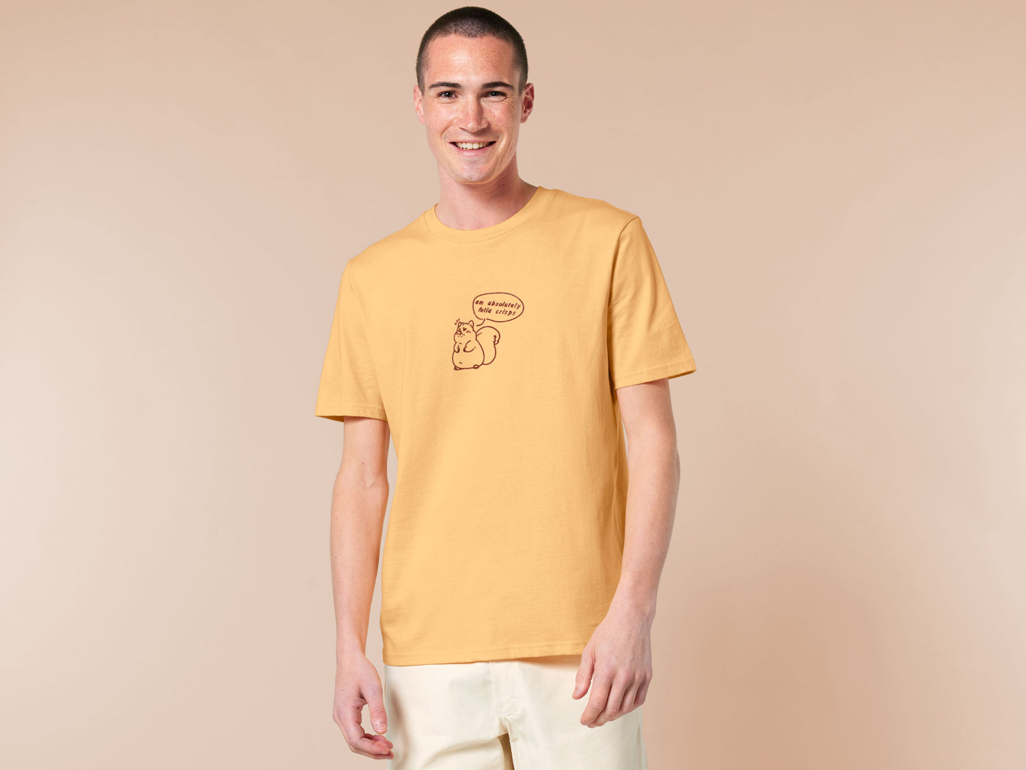 An embroidered yellow t-shirt design of a cute fat chibi squirrel and a speech bubble with the text Am Absolutely Fulla Crisps from the drunken Scottish meme video.