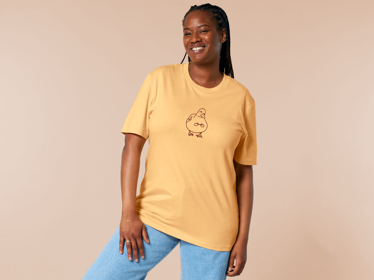 A yellow crew neck short sleeve t-shirt, with an embroidered black thread design of a cute blushing duck with the for me finger hand emoji symbols