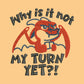 A yellow tshirt with an embroidered design of a cute grumpy red dragon playing a card game with the text why is it not my turn yet?!