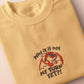 A yellow tshirt with an embroidered design of a cute grumpy red dragon playing a card game with the text why is it not my turn yet?!