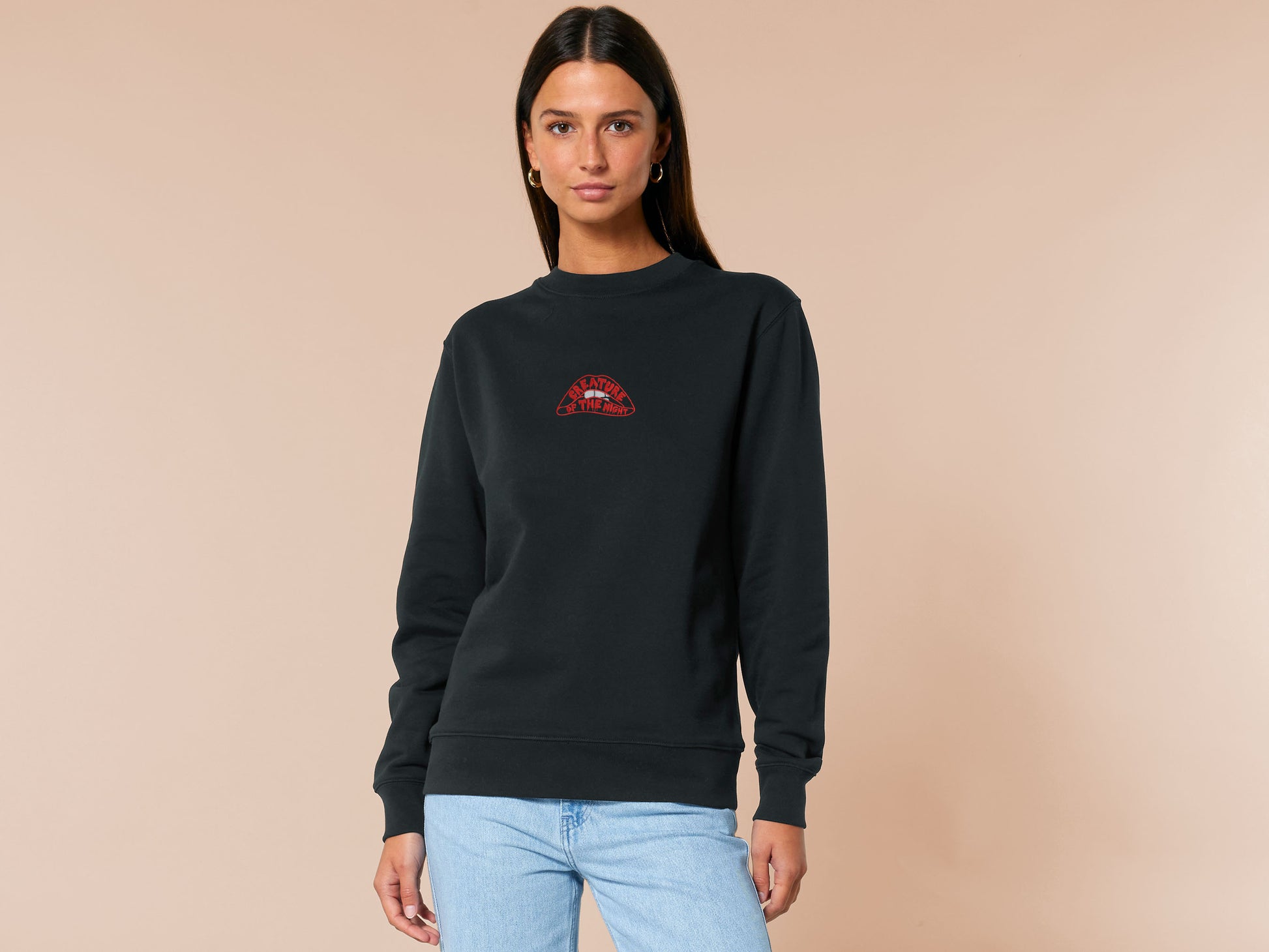 An Embroidered black sweater design of the iconicRocky Horror Show Double Feature cult classic sci-fi musical movie's lips with the text within the lips reading Creature of the night