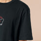 Embroidered black t-shirt with a cute chibi cryptid design of Mothman with the text I believe in Mothman (and Mothman believes in me!)