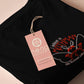Embroidered black t-shirt with a cute chibi cryptid design of Mothman with the text I believe in Mothman (and Mothman believes in me!)