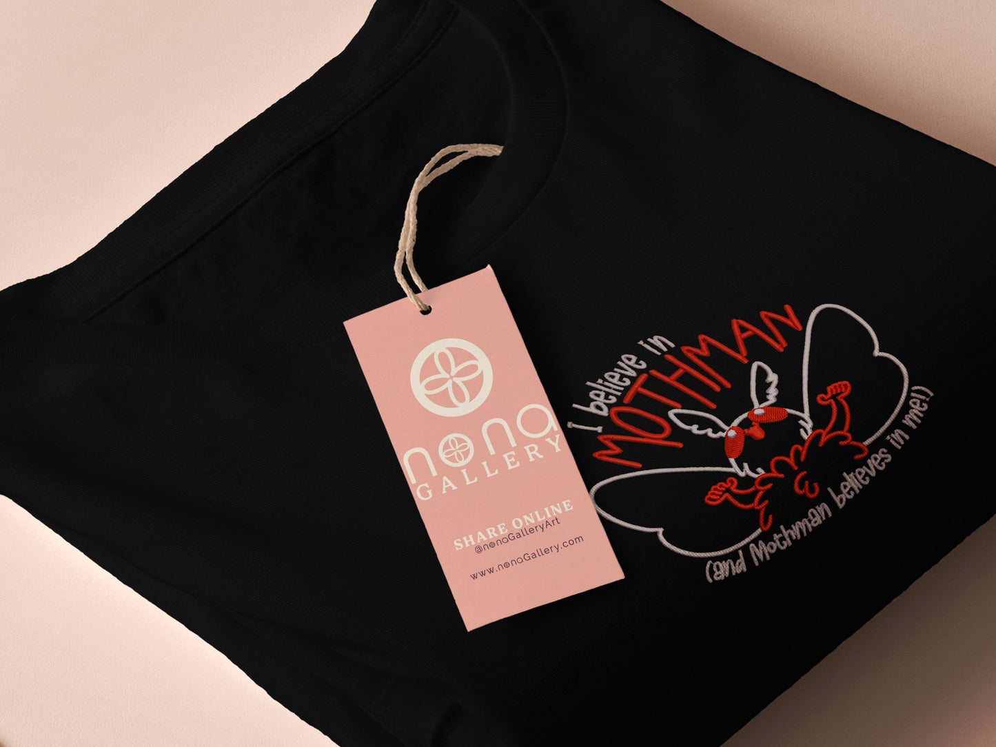 Embroidered black t-shirt with a cute chibi cryptid design of Mothman with the text I believe in Mothman (and Mothman believes in me!)