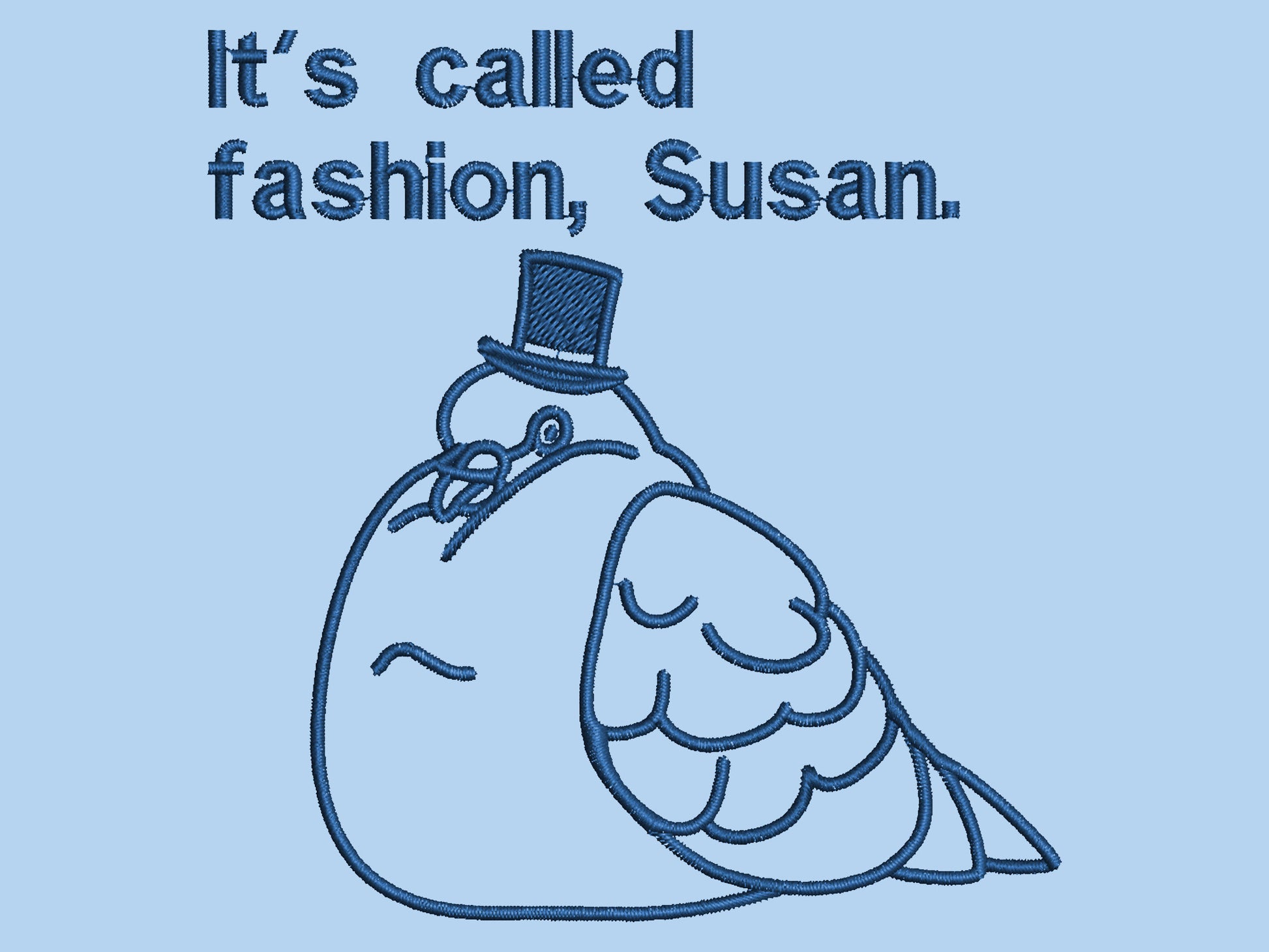 An embroidered blue tshirt design of a fat pigeon wearing a top hat and the text It's Called Fashion Susan