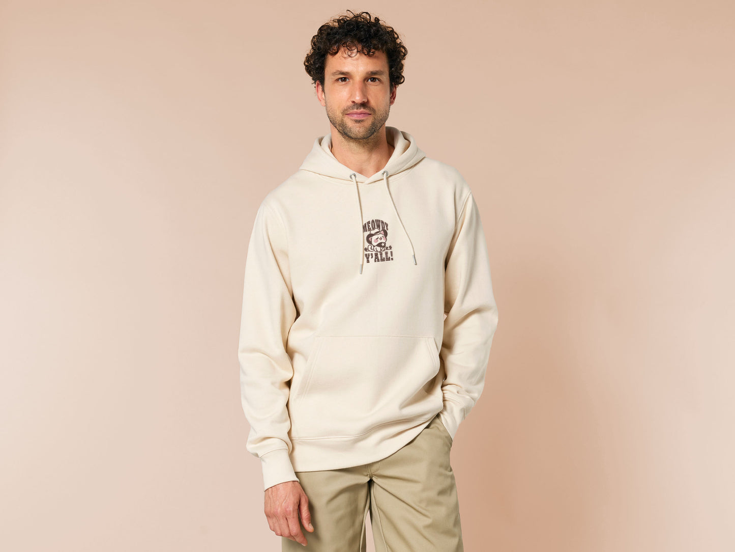 A cream crew neck long sleeve hoodie, with an embroidered brown thread design of a cute cowboy cat with hat surrounded by the quote meowfy ya'll!