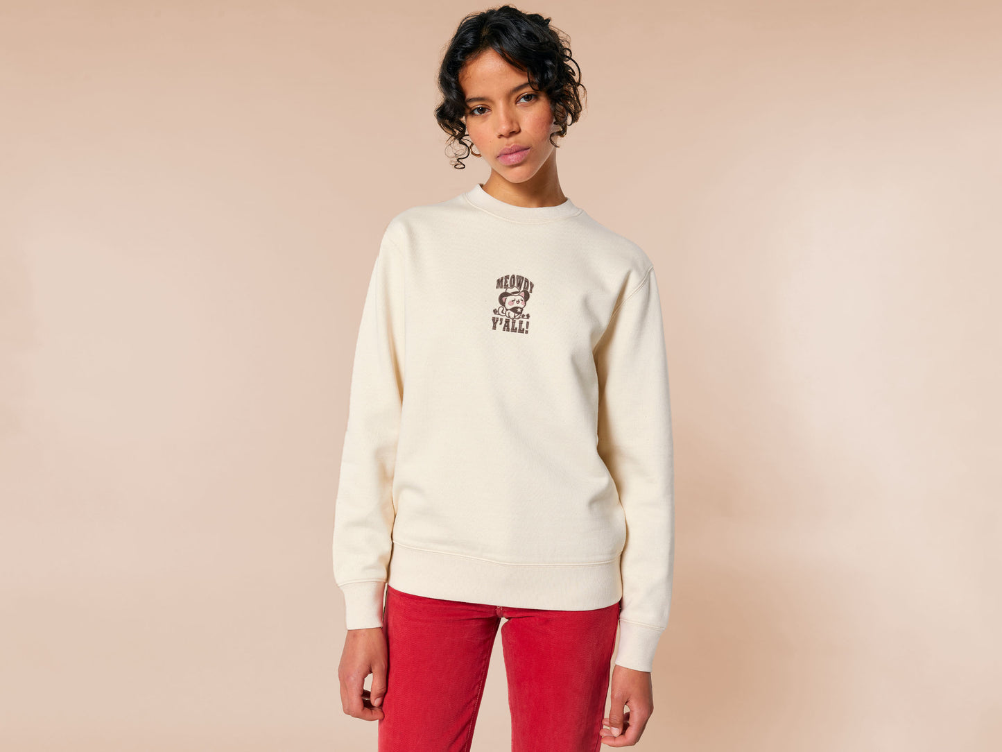 A cream crew neck long sleeve sweater, with an embroidered brown thread design of a cute cowboy cat with hat surrounded by the quote meowfy ya'll!