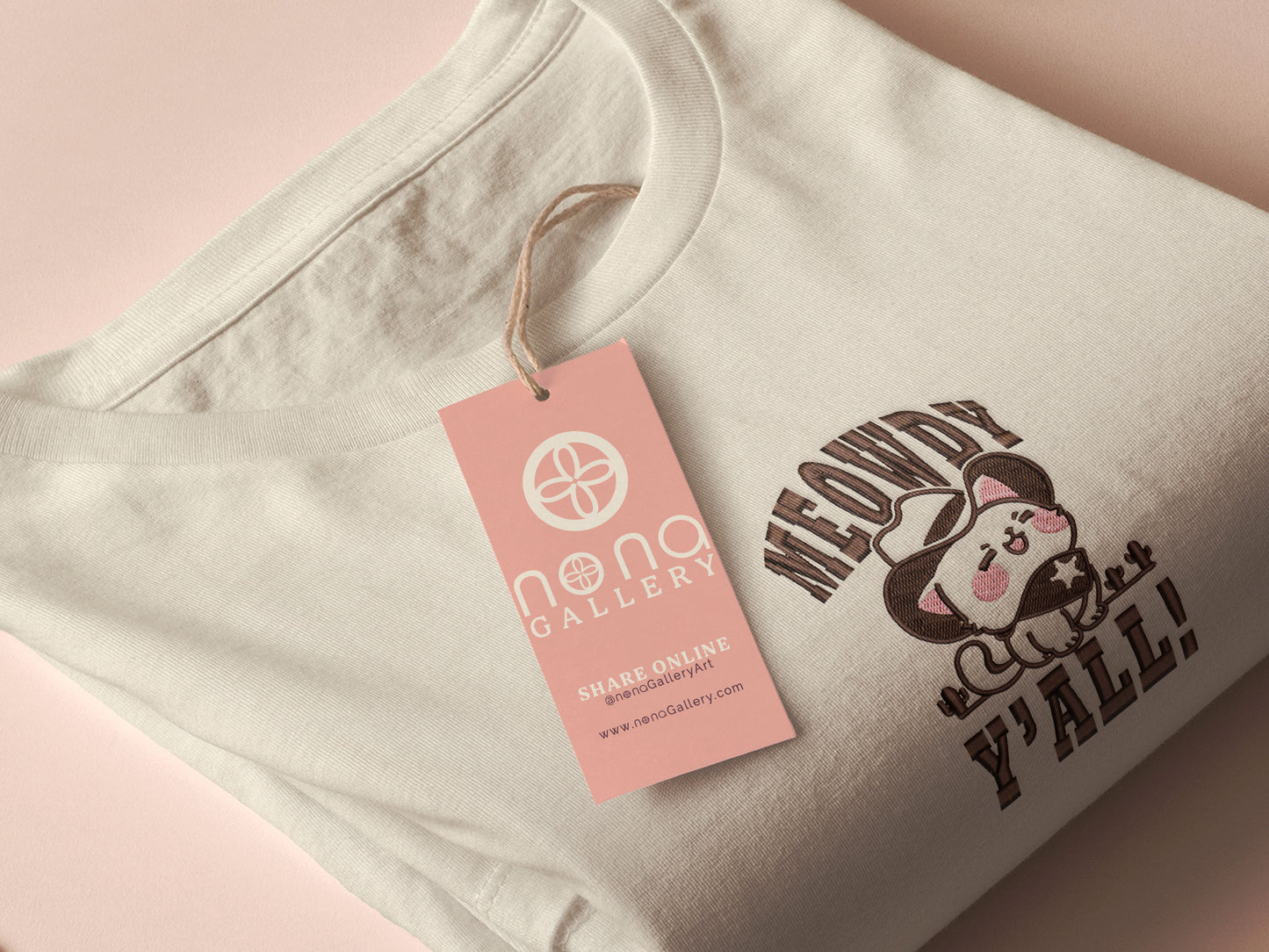 A cream crew neck short sleeve t-shirt, with an embroidered brown thread design of a cute cowboy cat with hat surrounded by the quote meowfy ya'll!