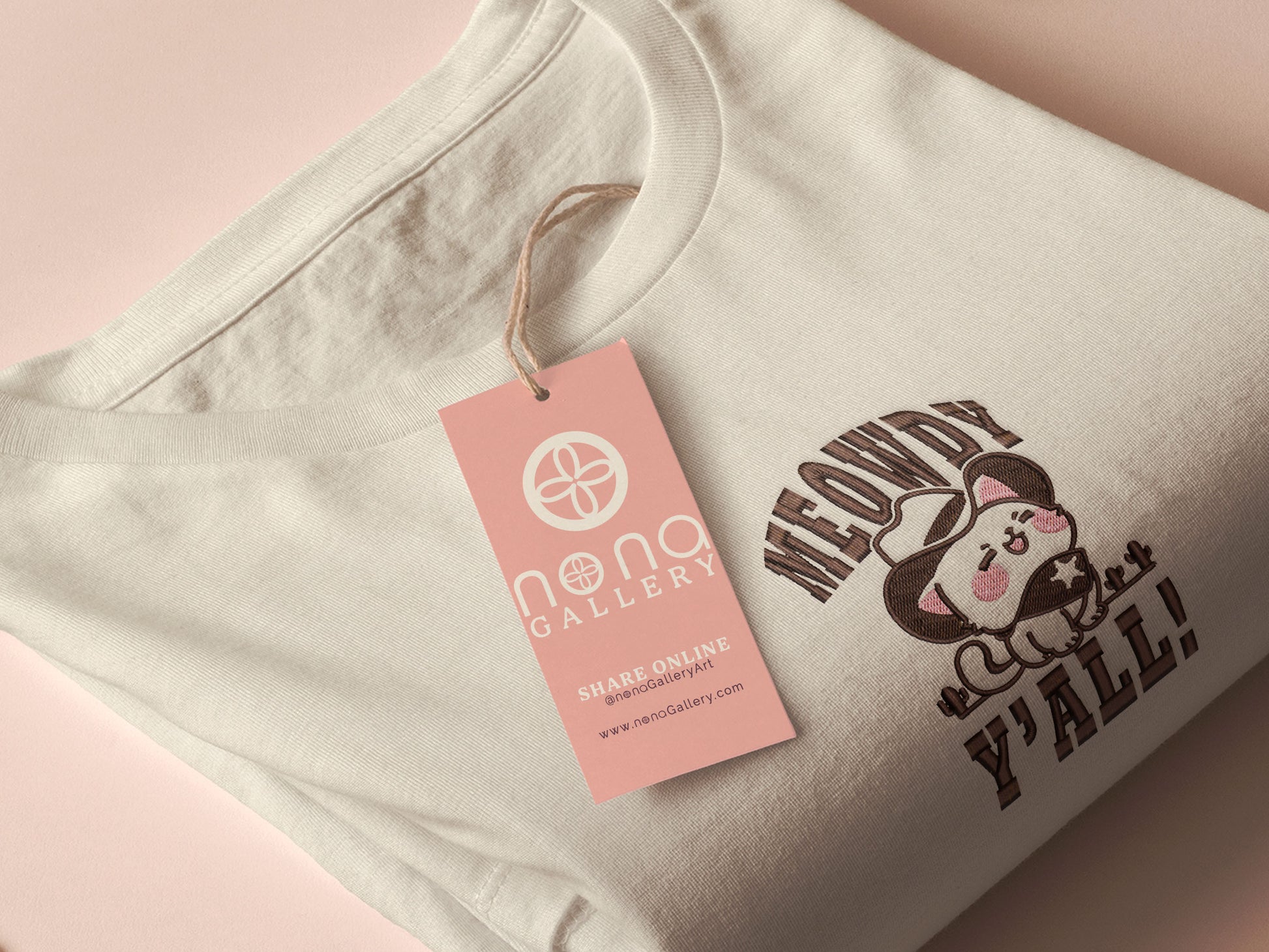 A cream crew neck short sleeve t-shirt, with an embroidered brown thread design of a cute cowboy cat with hat surrounded by the quote meowfy ya'll!