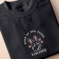 An embroidered dark grey t-shirt with a cute chibi bunny and the text Woke Up And Chose Violence.