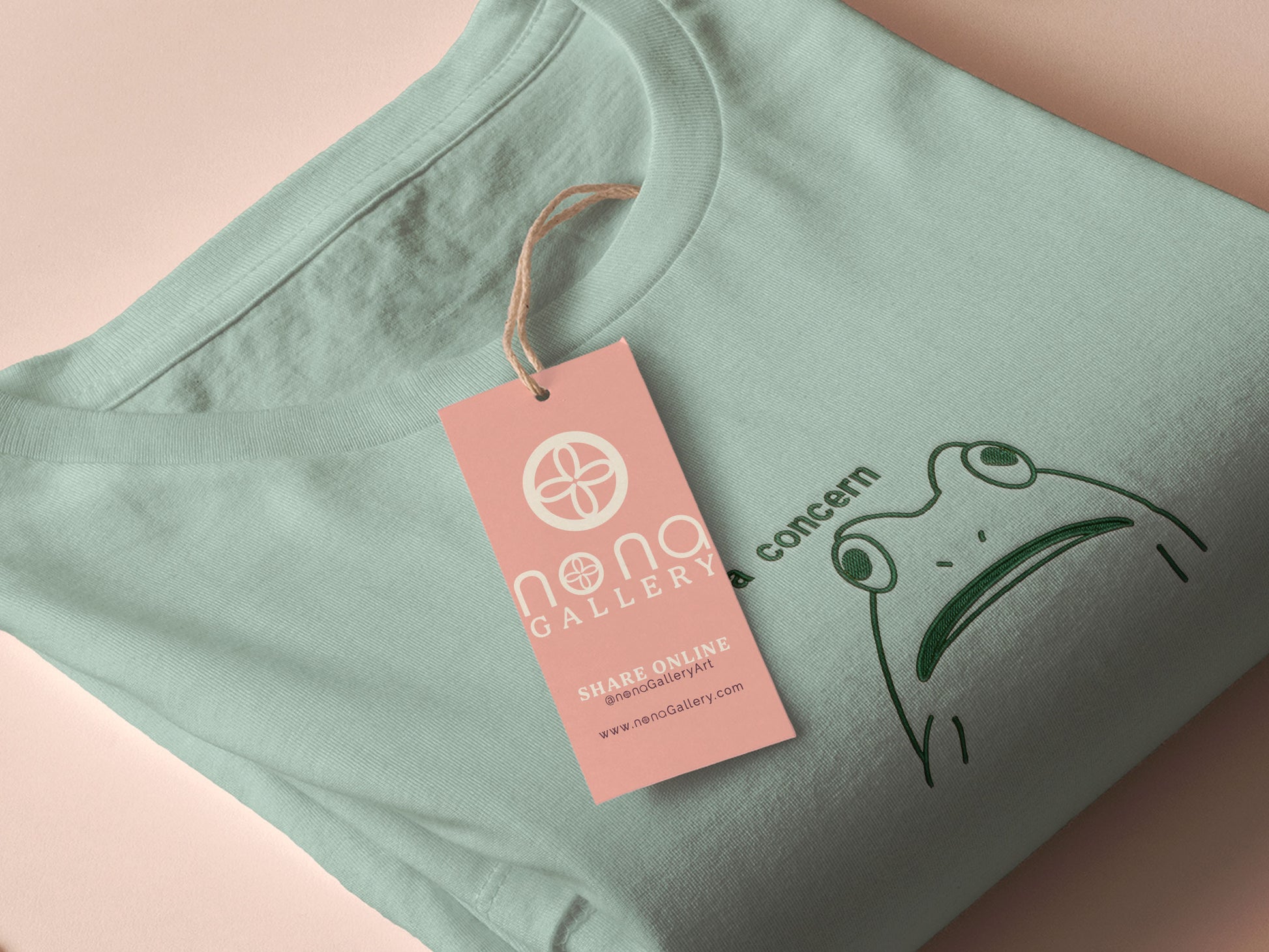 An embroidered green t-shirt design of a funny cartoon frog with the text a concern.