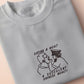 An embroidered light grey t-shirt design of the Australian Jack Karlson being arrested while he shouts Eating A Meal? A Succulent Chinese Meal?!