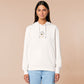 An embroidered white hoodie design of a cute cartoon goose wearing a paper hat with text underneath that reads you silly goose.
