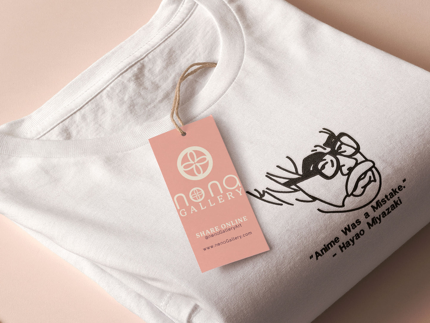 A off white crew neck short sleeve t-shirt, with an embroidered black thread design of a portrait of a depressed Hayao Miyazaki the creator of Studio Ghibli with text underneath that reads "Anime Was A Mistake." - Hayao Miyazaki