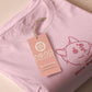 A pink crew neck short sleeve t-shirt, with an embroidered pink thread design of a cute fat cat portrait with text underneath saying (Heavy Breathing)