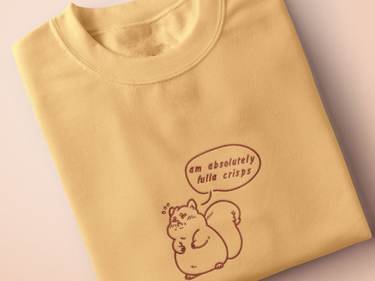 An embroidered yellow t-shirt design of a cute fat chibi squirrel and a speech bubble with the text Am Absolutely Fulla Crisps from the drunken Scottish meme video.
