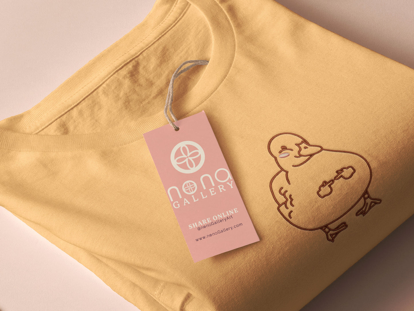 A yellow crew neck short sleeve t-shirt, with an embroidered black thread design of a cute blushing duck with the for me finger hand emoji symbols