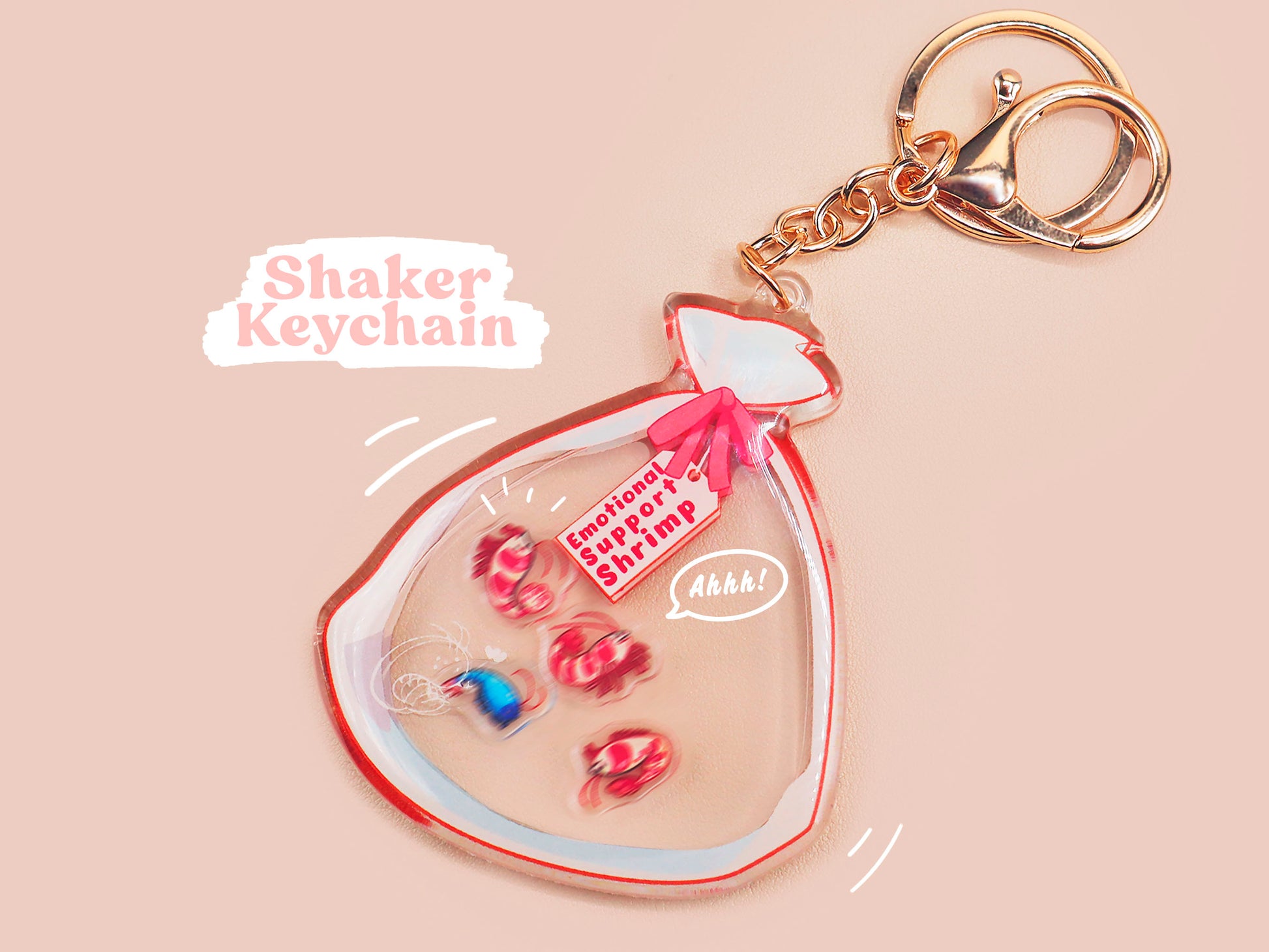 A large transparent acrylic shaker keychain with gold keyring, filled with mini chibi shrimps and labelled as emotional support shrimp