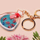 A large transparent acrylic shaker keychain with gold keyring, filled with mini chibi shrimps and labelled as emotional support shrimp