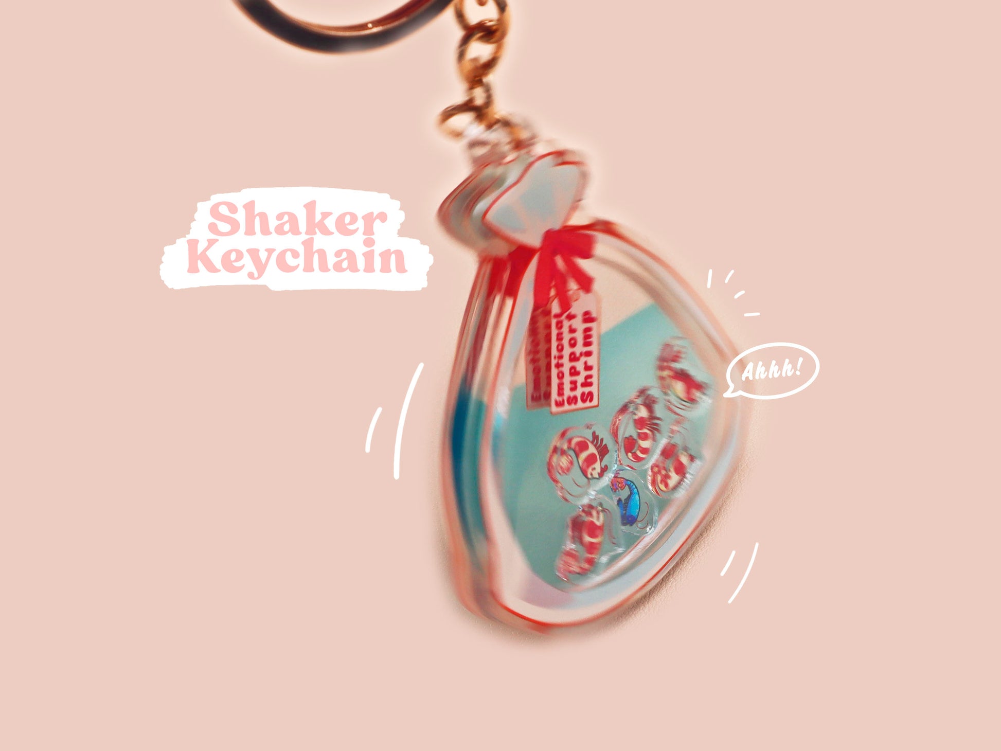 A large transparent acrylic shaker keychain with gold keyring, filled with mini chibi shrimps and labelled as emotional support shrimp