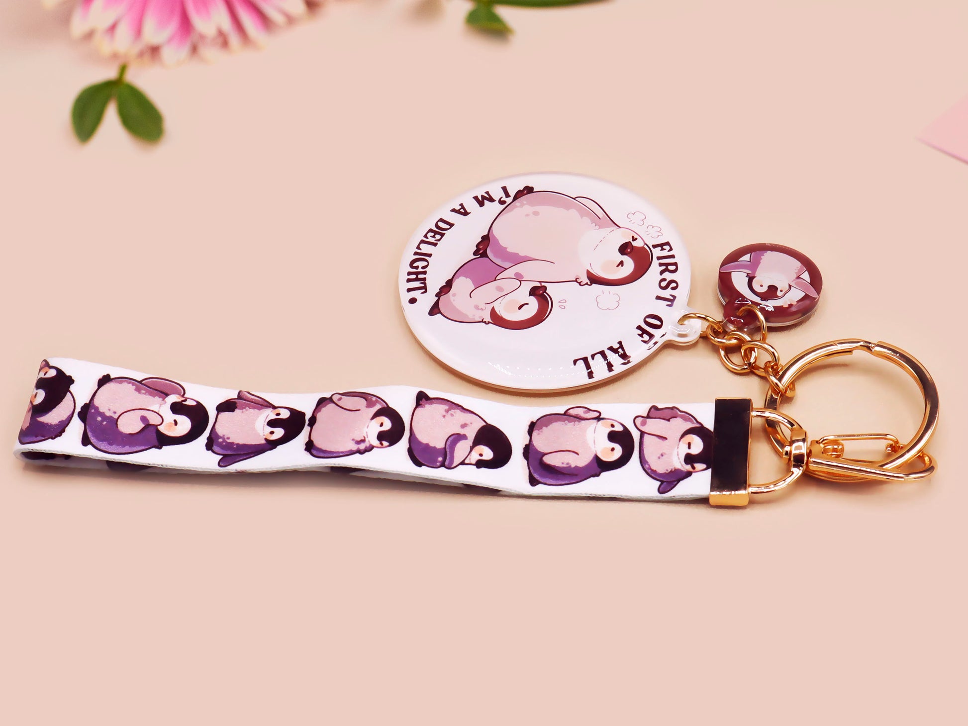 Acrylic epoxy baby penguin keychain with a large acrylic charm of two baby penguins with the quote first of all I'm a delight, a smaller charm of a cute penguin and a matching baby emperor penguin lanyard.
