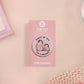 A clear acrylic pin badge with a pink heart-shaped pin back clasp. The design of the pin badge is of a cute baby penguin chicks squabbling with the quote first of all I'm a delight.