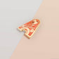 Top part of the Gold Enamel Talisman Pin with red design and the words Couple's Talisman, Always & Forever. The pins design includes a hearts, ducks, as well as flowers and crystals.
