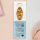 Gold Enamel Talisman Pin with yellow design and the words Gamer's Talisman sits on a long white and blue backing card with gold accents. The backing card has details the symbolism of the different design elements of the Talisman pin.