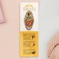 Gold Enamel Talisman Pin with green design and the words Teacher's Talisman sits on a long white and yellow backing card with gold accents. The backing card has details the symbolism of the different design elements of the Talisman pin.