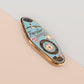 A Traveller's Talisman gold enamel pin on a gold foiled backing card that outlines the symbolism of the talisman including information and imagery on the albatross, periwinkle flowers and Malachite crystals.
