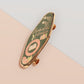 A Bookworm's Talisman gold enamel pin on a gold foiled backing card that outlines the symbolism of the talisman including information and imagery on double shooting stars, sage leaves and brecciated jasper.