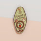 A Plant Person's Talisman gold enamel pin on a gold foiled backing card that outlines the symbolism of the talisman including information and imagery on sliced oranges, heather stems, and moss agate