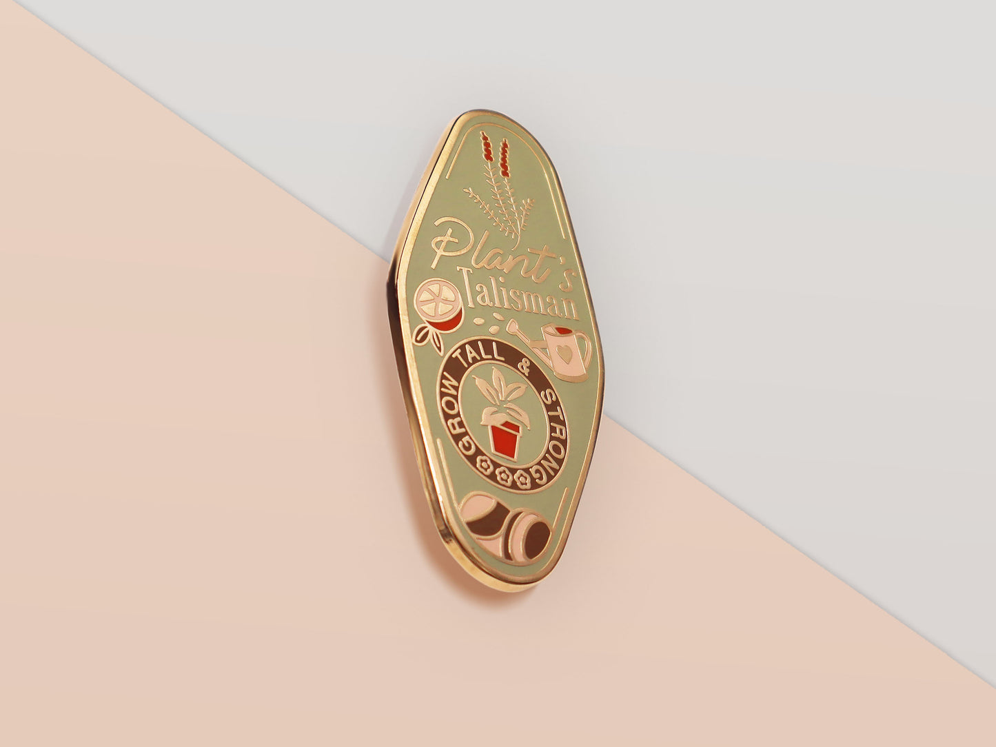 A Plant Person's Talisman gold enamel pin on a gold foiled backing card that outlines the symbolism of the talisman including information and imagery on sliced oranges, heather stems, and moss agate