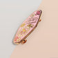 An Animal Lover's Talisman gold enamel pin on a gold foiled backing card that outlines the symbolism of the talisman including information and imagery on Magnolia flowers, yellow roses, and aragonite star clusters