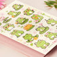 A large pastel coloured gloss vinyl sticker sheet with multiple cute frogs and lily pad stickers