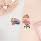 Two peelable stickers, the first stickers is a gaming mouse with a ribbon and text that reads GG Well Played. The Second sticker is a gaming chair with flowers and a speech bubble that reads I'd rather be gaming.