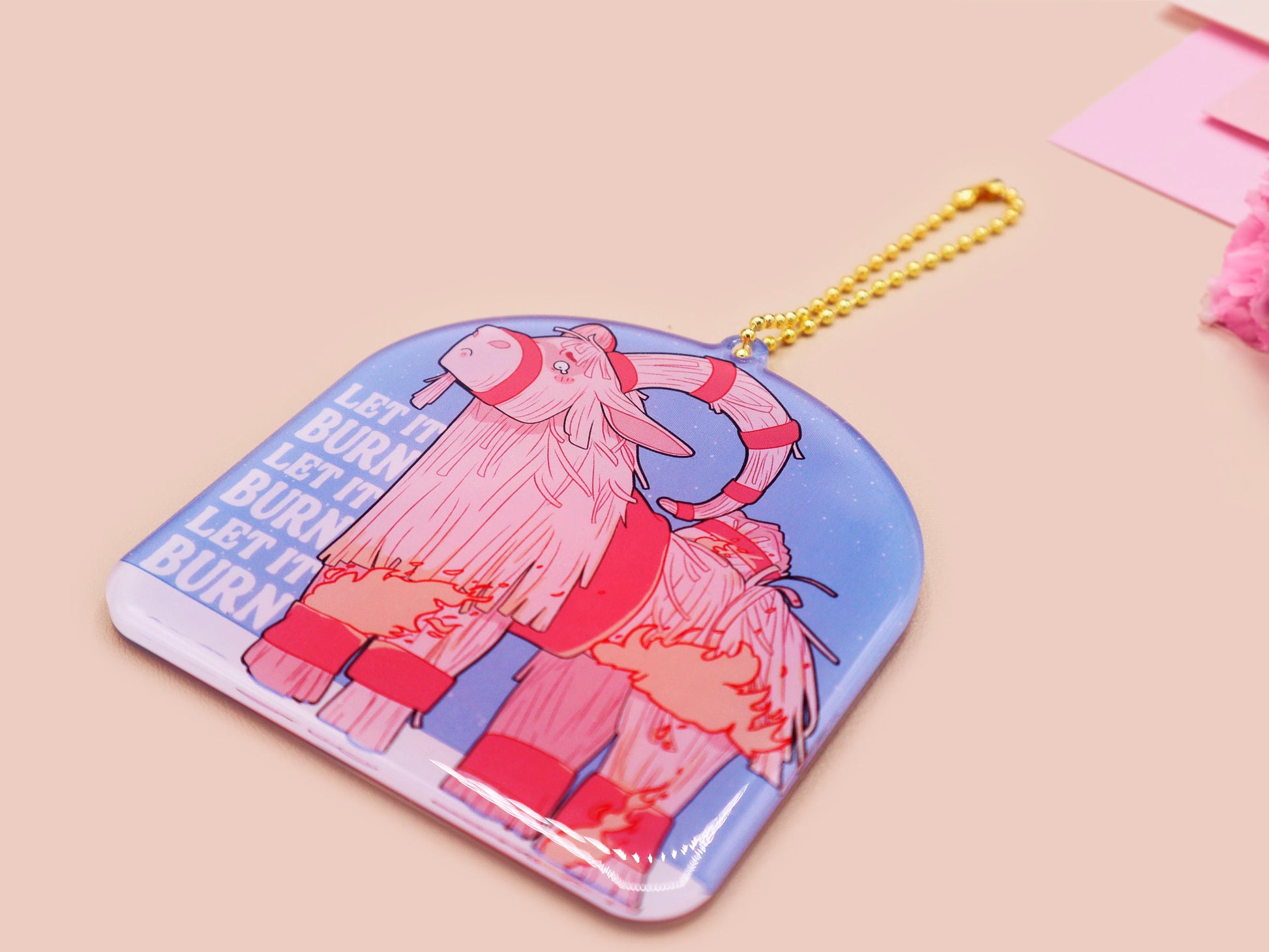 Acrylic epoxy christmas tree hanging decoration with a large acrylic charm of a cute crying gavle straw goat in the snow on fire with the quote let it burn let it burn let it burn