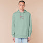 An embroidered green hoodie design of a cute alien cat floating in space surrounded by stars and planets and by the quote beam me up! I want to leave