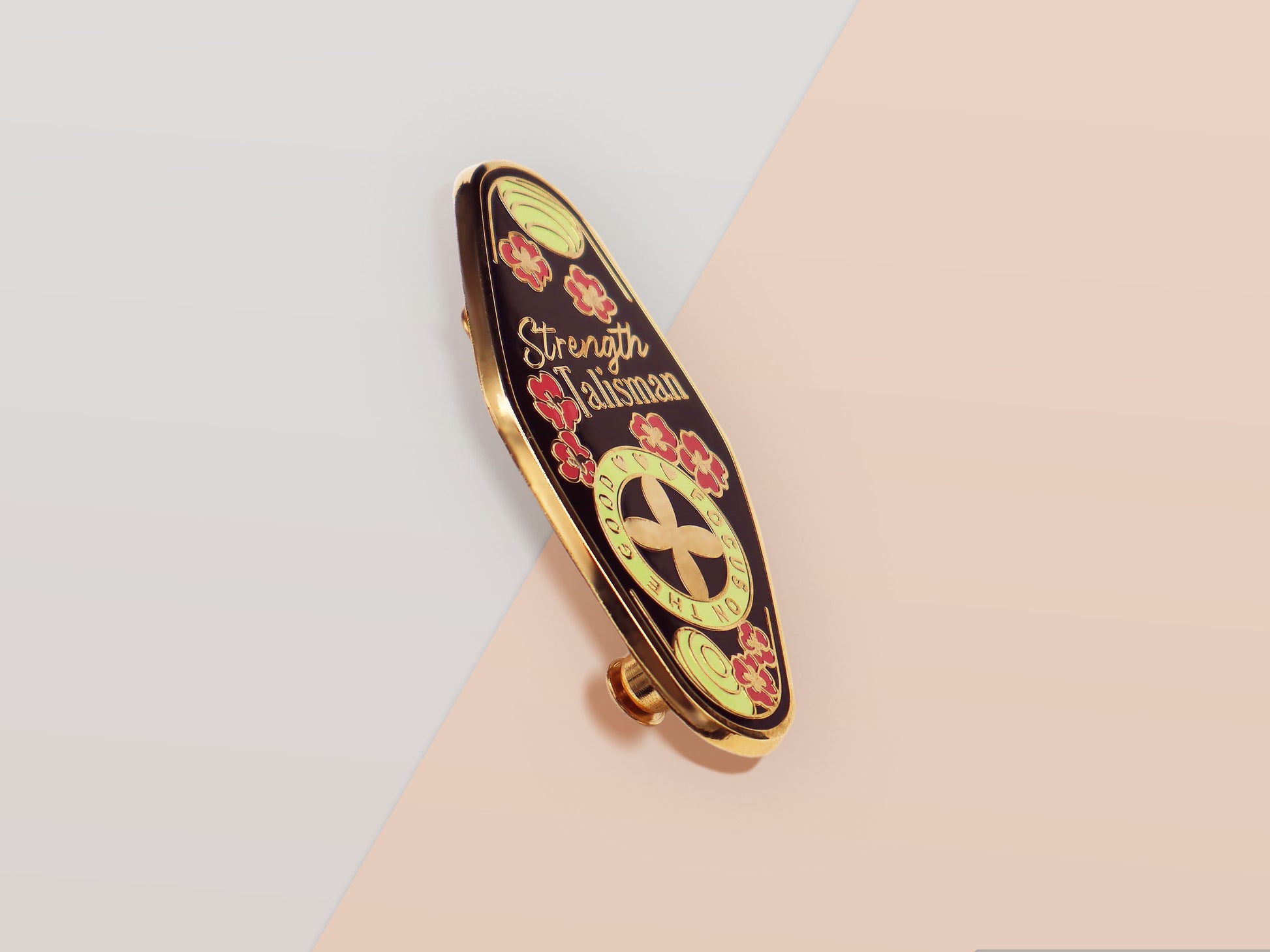The Strength Talisman gold enamel pin on a gold foiled backing card that outlines the symbolism of the talisman including information and imagery on the Tabono adinkra Symbol, potential flowers, and chrysoprase stones