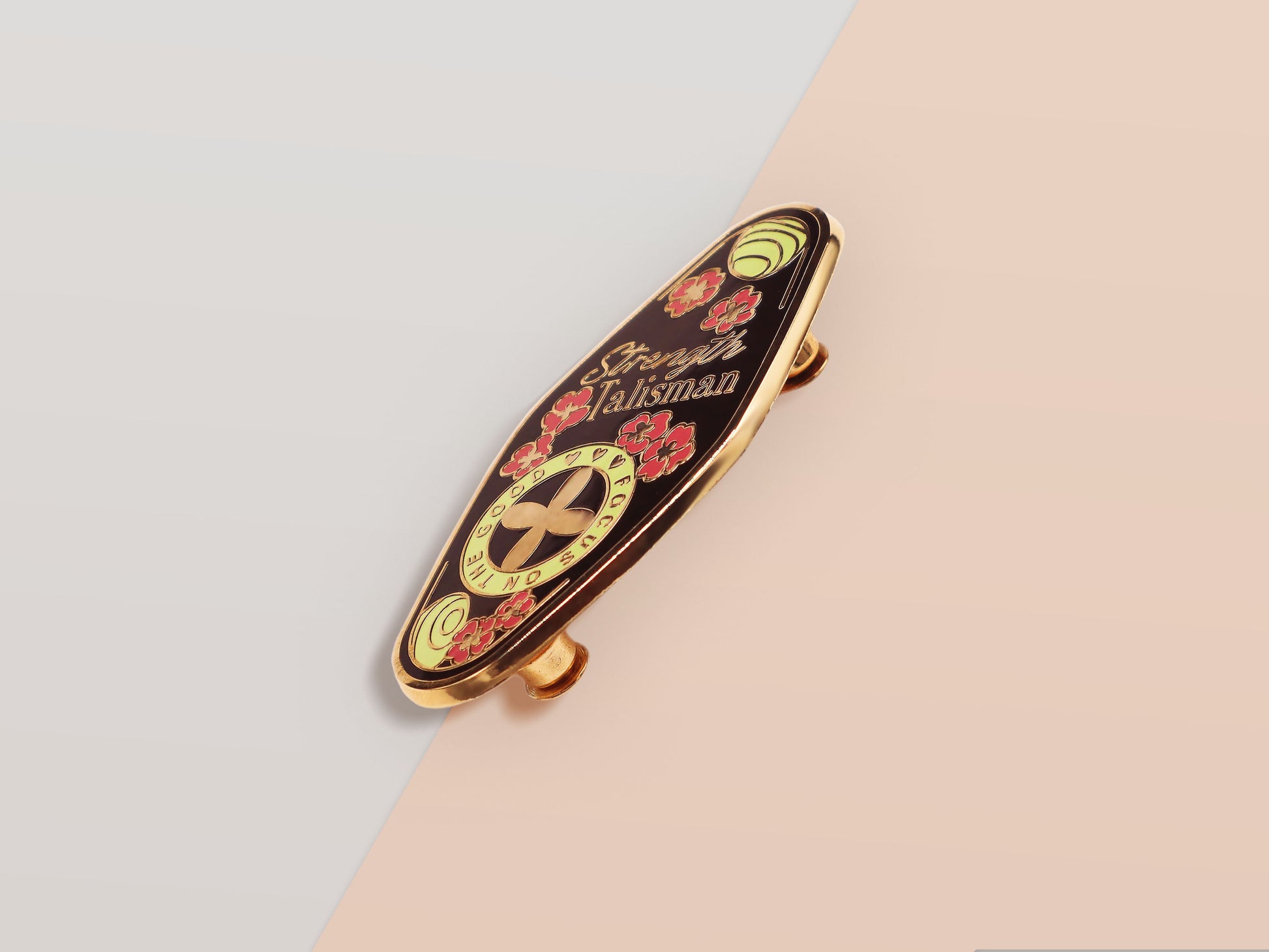 The Strength Talisman gold enamel pin on a gold foiled backing card that outlines the symbolism of the talisman including information and imagery on the Tabono adinkra Symbol, potential flowers, and chrysoprase stones